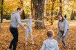 © Strelciuc - Young family of four members rejoicing in a forest throwing leaves in the air on an autumns day. Fall foliage. Family outdoor fun in autumn. Toddler or