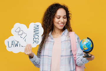 Young black teen girl student she wear casual clothes backpack bag hold Earth world globe card sign with professions isolated on plain yellow color background High school university college concept