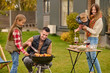 © zinkevych - Family of four people enjoying a backyard picnic