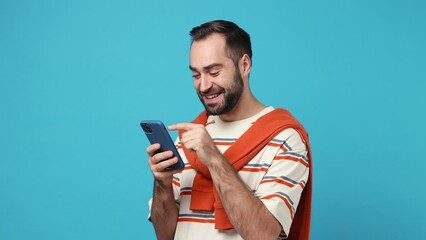 Wall Mural - Young brunet man 20s wears striped t-shirt hold use mobile cell phone swipe browsing do online shopping order order delivery to home booking tour isolated on plain pastel light blue background studio