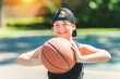 portrait of a boy kid playing with a basketball in park