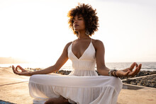 Beautiful African Woman In Yoga Position With Sunset Background.