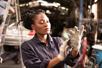 Wall Mural - African american technician female Mechanic working under the hood at the repair garage.