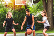 three teens in sportswear playing basketball game