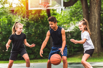 Wall Mural - three teens in sportswear playing basketball game