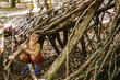 © ADDICTIVE STOCK - Boy building shelter from sticks