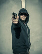 © bogdan vacarciuc - A man armed with a gun opens fire. Armed attack, robbery - concept.