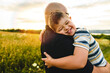 Portrait of a little boy with down syndrome in sunset on summer season with his father