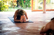 © Cavan Images - Woman practicing seated forward bend pose in yoga studio