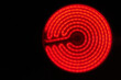 Glowing burner of the electric hotplate on black background