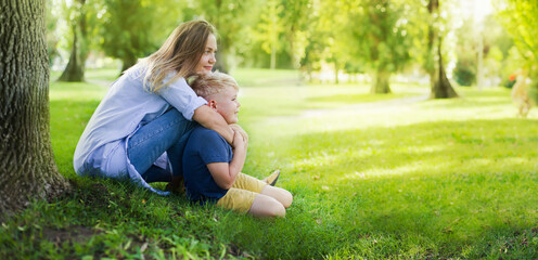 Wall Mural - beautiful happy family mother and son relaxing in the summer park 