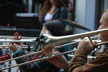 Wall Mural - A group of musicians playing wind instruments trumpet and trombone on the street