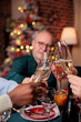 © DC Studio - Diverse people hands clinking glasses with sparkling wine closeup, proposing christmas toast, drinking alcohol at festive dinner close view. Winter holiday celebration, xmas party