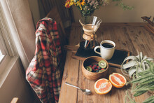 High Angle View Of Fruits With Coffee And Potted Plant On Wooden Table