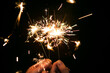 © Cavan Images - Cropped hands of woman holding sparklers