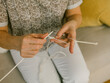 © Cavan Images - High angle view of woman knitting while sitting on sofa at home