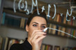 © Cavan Images - Businesswoman writing formula on glass wall at office