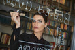 © Cavan Images - Businesswoman writing formula on glass wall