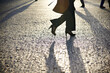 © Cavan Images - Low section of businesswoman walking on cobbled footpath