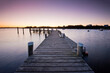 © Cavan Images - Wooden pier over sea against clear sky during sunrise