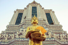 Low Angle View Of Buddha Statue By Wat Arun Temple Against Sky