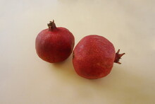 Two Red Pommegrante Fruits On Golden Background