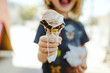 © Cavan Images - Midsection of boy holding melting ice cream cone while standing outdoors