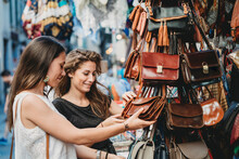 Female Friends Buying Purse At Market