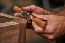 Cropped Hands Of Carpenter Shaping Wood With Work Tool In Workshop