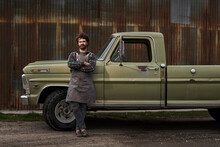 Portrait Of Confident Carpenter With Arms Crossed Standing By Pick-up Truck On Road