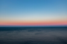 Scenic View Of Seascape Against Clear Sky During Sunset