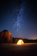 Illuminated Tent On Landscape Against Star Field At Night
