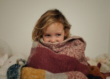 Girl Aged 4 Playing In Bedroom Wrapped In Blanket Having Fun
