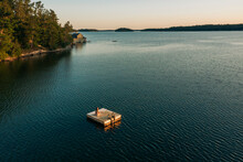 Woman On A Dock On A Lake In Muskoka Canada At Sunset