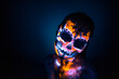© Cavan Images - Girl's face painted UV skull