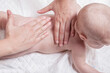 © Cavan Images - 3 month baby boy receiving back massage from a massage therapist