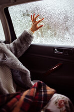 Female Hand Draws On A Snow-covered Window.