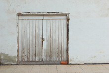 Old  White Door On A White Painted Wall And A Brown Brick.