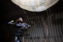 Girl In A Tunnel In Mid Throw Of A Softball