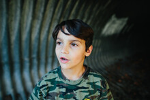 Boy Looks Slightly Surprised While Inside A Tunnel