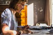© Cavan Images - Young woman drawing architect plans and smiling on desk