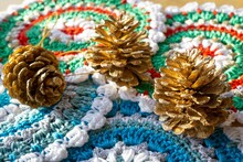 Handmade Crochet Placemats And Sprayed Gold Pine Cone Decorations For The Christmas Table
