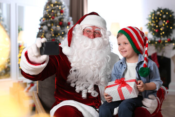 Wall Mural - Santa Claus and little boy taking selfie in room decorated for Christmas