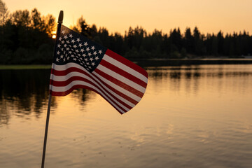 American flag on the sunset lake background. USA holiday concept