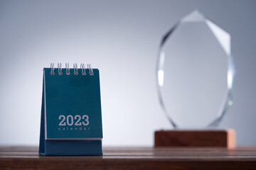 Wall Mural - close up of a glass trophy and desk calendar 2023