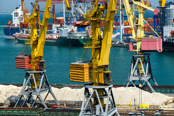 Wall Mural - industrial seaport infrastructure - sea, cranes and minerals, metal and bundles of wire, railcars on railroad, concept of marine cargo transportation