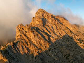 Fototapete - Sunrise in the Dolomites mountains with mist and clouds in the early morning. Fog rolling around the mountain peaks. 