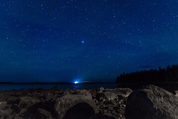 Wall Mural - starry sky with constellations, galaxies, milky way and many stars above water of river with stones 