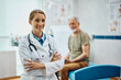 © Drazen - Portrait of happy confident doctor with her senior patient in background.