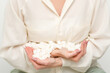 © okskukuruza - Portrait of young caucasian woman holding sugar cubes heap standing and looking at the camera against a white background